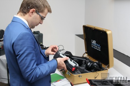 Участник конференции знакомится с микроомметром MOM2